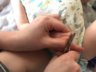 Das Kind bekommt die Nägel geschnitten