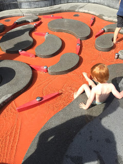 Das Kind spielt glücklich auf dem Wasserspielplatz Koblenz